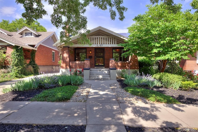 3237 N Josephine St, Denver, CO 80205 - view of front of home featuring brick siding, covered porch, and solar panels