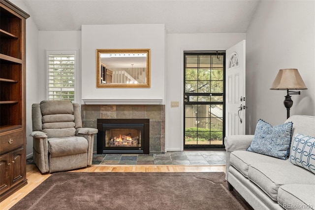 living area featuring plenty of natural light and a tiled fireplace