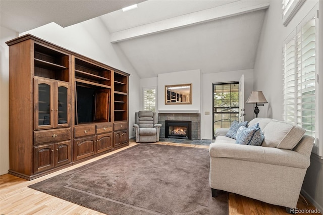 living area with light wood-type flooring and a tiled fireplace
