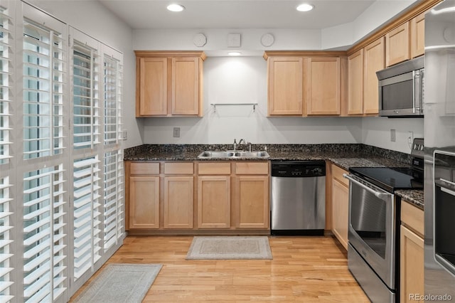 kitchen featuring appliances with stainless steel finishes, a sink, light brown cabinets, light wood-type flooring, and recessed lighting