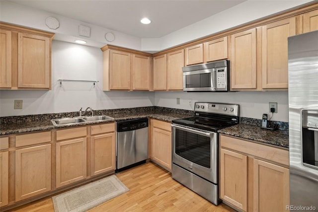 kitchen with stainless steel appliances, a sink, light brown cabinets, light wood-style floors, and recessed lighting