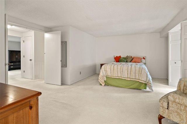 bedroom featuring light colored carpet, a textured ceiling, and baseboards