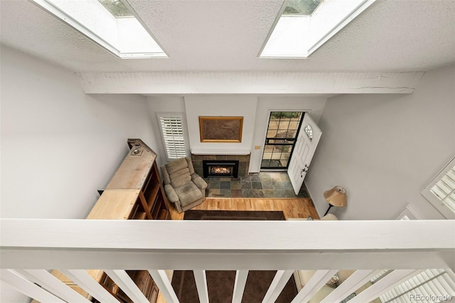 living room featuring a skylight, a tile fireplace, and a textured ceiling