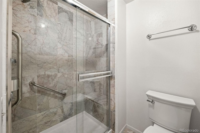 bathroom with toilet and a stall shower