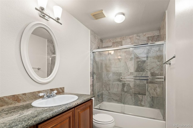 bathroom with combined bath / shower with glass door, toilet, and vanity