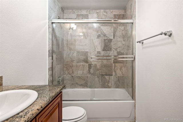 bathroom featuring vanity, shower / bath combination with glass door, and toilet