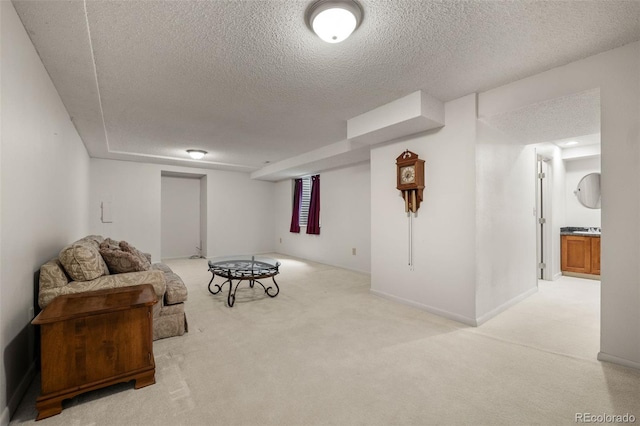 living area featuring a textured ceiling and light colored carpet