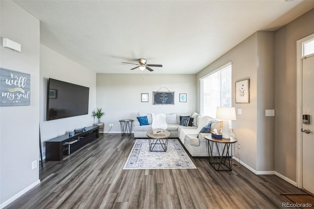 living area with dark wood finished floors, baseboards, and a ceiling fan