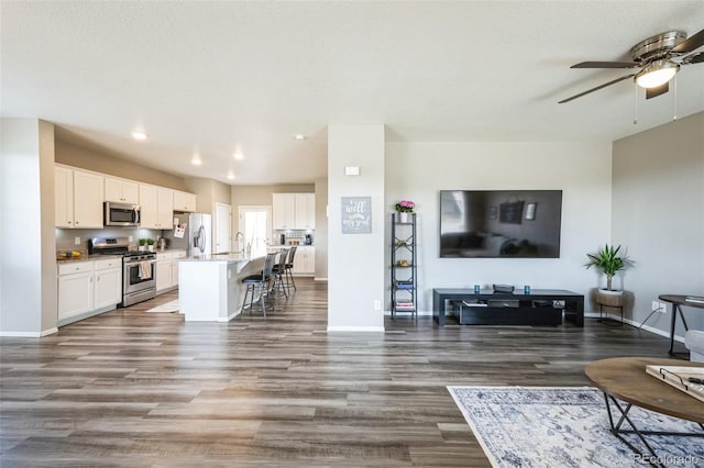 living room featuring wood finished floors, recessed lighting, a ceiling fan, and baseboards