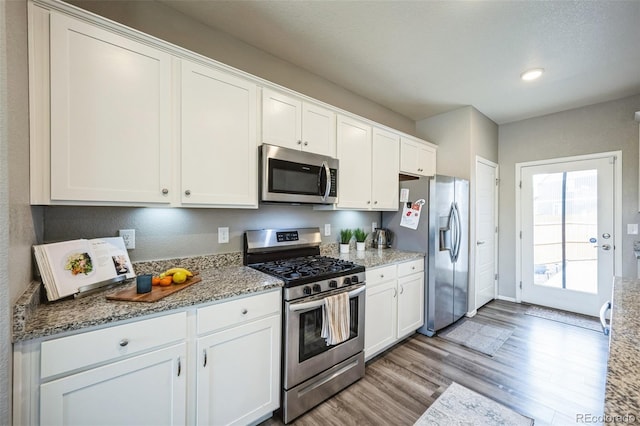 kitchen featuring light stone counters, light wood-style flooring, white cabinetry, and stainless steel appliances