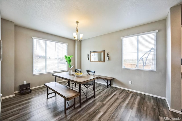 dining room featuring baseboards, a textured ceiling, an inviting chandelier, and dark wood finished floors