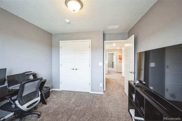 office space with visible vents, a textured ceiling, baseboards, and carpet floors