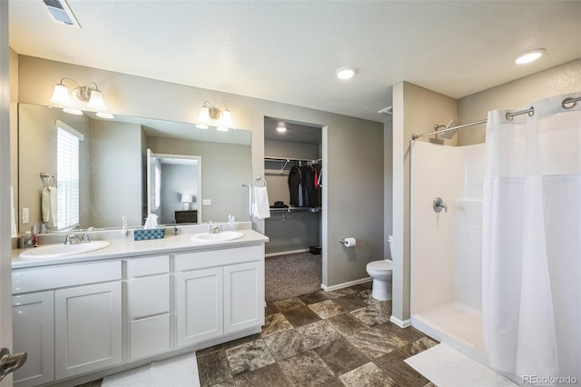 full bath featuring double vanity, a shower with curtain, baseboards, and a sink