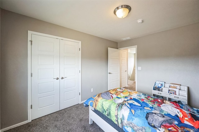 bedroom featuring a closet, carpet floors, baseboards, and visible vents