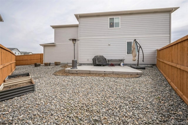 rear view of property featuring a patio area and a fenced backyard
