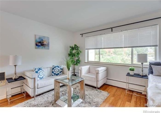 living room with baseboard heating and light wood-type flooring