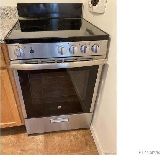 details featuring light stone counters, stainless steel electric stove, and light brown cabinets