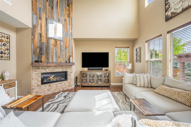 10057 Des Moines St, Parker, CO 80134 - living area with a towering ceiling, wood finished floors, plenty of natural light, baseboards, and a glass covered fireplace