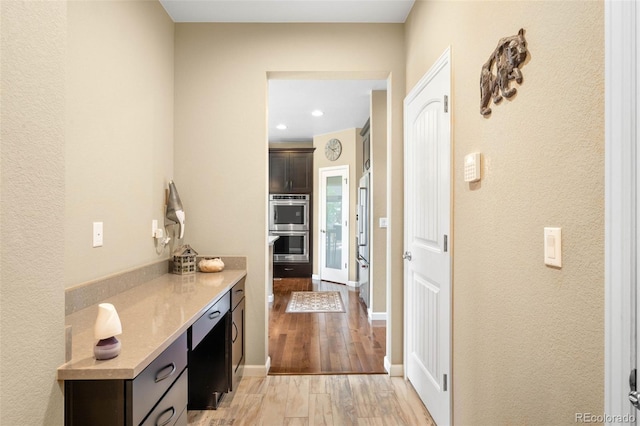 10057 Des Moines St, Parker, CO 80134 - hall with light wood finished floors, baseboards, recessed lighting, and a textured wall