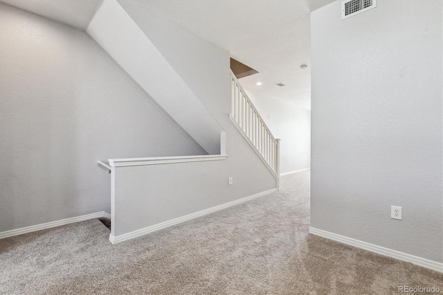 stairway featuring carpet and baseboards