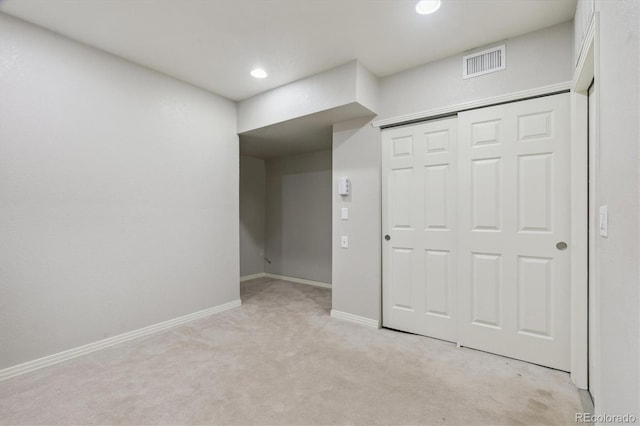 unfurnished bedroom with light colored carpet, baseboards, a closet, and recessed lighting
