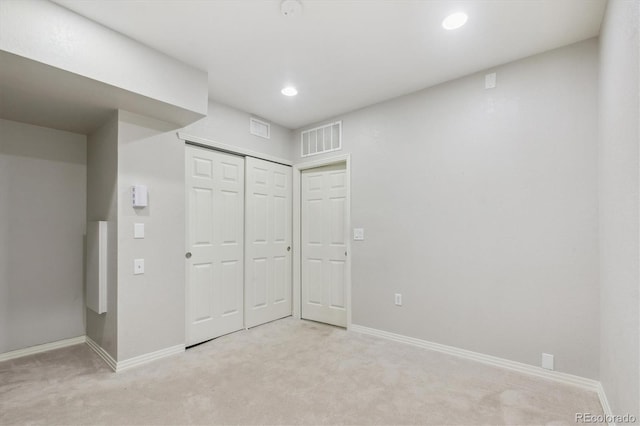 unfurnished bedroom with light carpet, baseboards, recessed lighting, and a closet