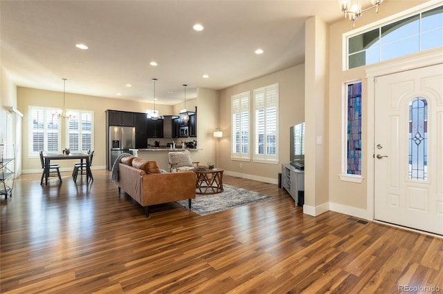 foyer entrance with dark wood-type flooring and an inviting chandelier