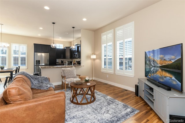 living room with wood-type flooring and a notable chandelier