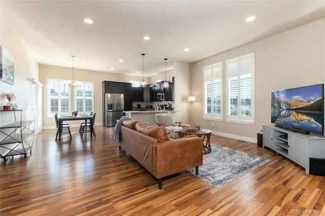 living room with dark hardwood / wood-style flooring and a chandelier