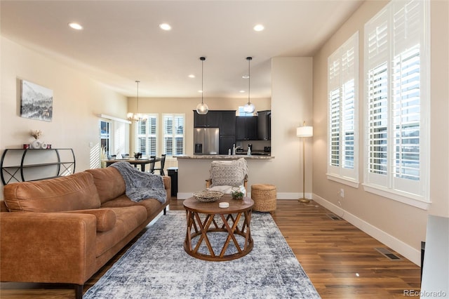 living room featuring dark wood-type flooring and a chandelier