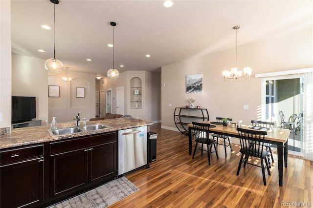 kitchen with dishwasher, wood-type flooring, hanging light fixtures, and sink