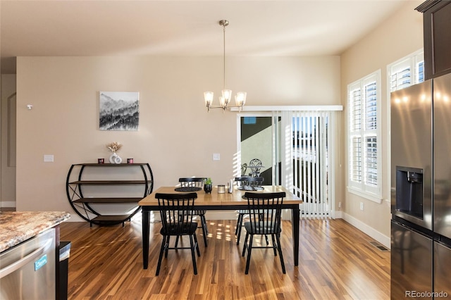 dining room featuring dark wood-type flooring and an inviting chandelier