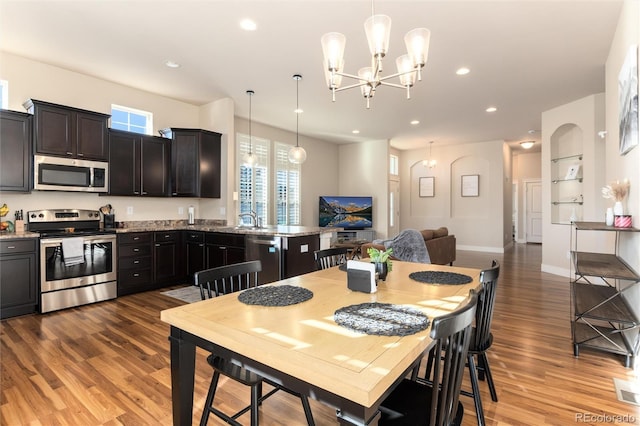 dining space with an inviting chandelier, hardwood / wood-style floors, and sink