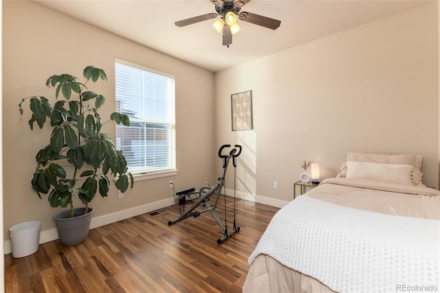 bedroom with ceiling fan, dark wood-type flooring, and multiple windows