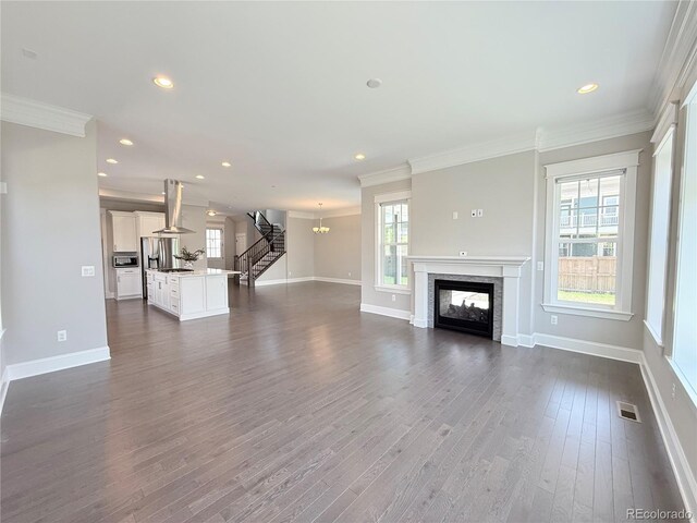 6023 Chester Way, Denver, CO 80238 - unfurnished living room featuring crown molding, baseboards, recessed lighting, dark wood-style floors, and stairs