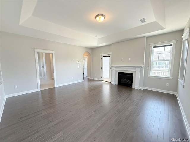 6023 Chester Way, Denver, CO 80238 - unfurnished living room featuring a raised ceiling, dark wood-style flooring, and arched walkways