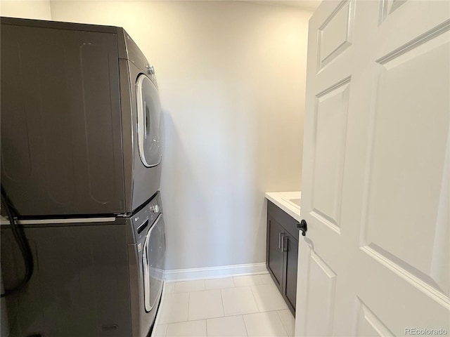 6023 Chester Way, Denver, CO 80238 - laundry room featuring stacked washer / drying machine, cabinet space, baseboards, and light tile patterned flooring