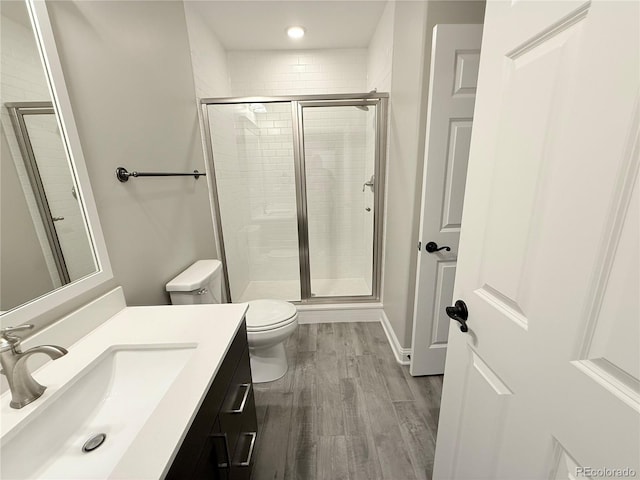 6023 Chester Way, Denver, CO 80238 - full bathroom featuring toilet, vanity, a stall shower, wood finished floors, and recessed lighting