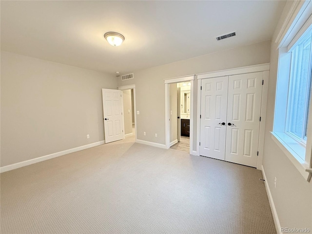 6023 Chester Way, Denver, CO 80238 - unfurnished bedroom with baseboards, a closet, light colored carpet, and ensuite bath