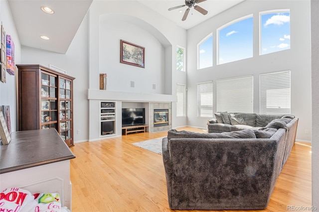 24022 E Jamison Dr, Aurora, CO 80016 - living room with healthy amount of natural light, a ceiling fan, light wood-type flooring, a towering ceiling, and recessed lighting