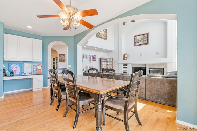 24022 E Jamison Dr, Aurora, CO 80016 - dining space with a ceiling fan, light wood-type flooring, arched walkways, a tiled fireplace, and recessed lighting