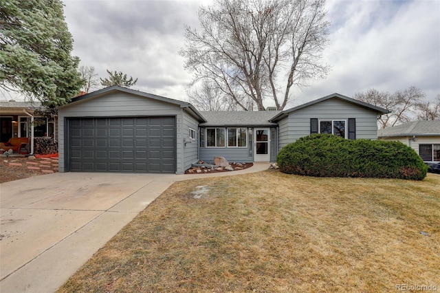 single story home featuring a front yard, concrete driveway, and an attached garage