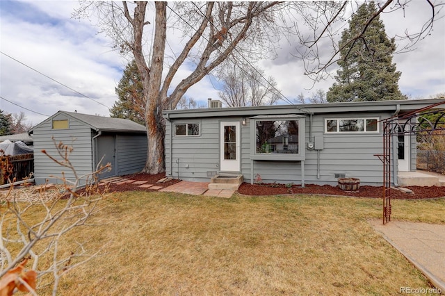 view of front of home with an outbuilding, fence, a front lawn, and entry steps