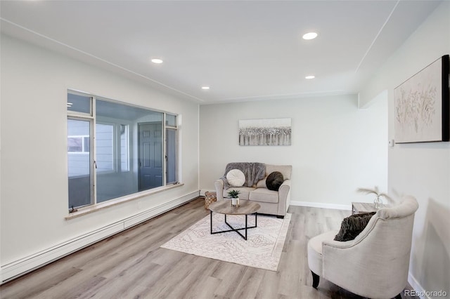 living area featuring baseboards, a baseboard heating unit, wood finished floors, and recessed lighting