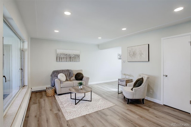 living area with baseboards, wood finished floors, and recessed lighting