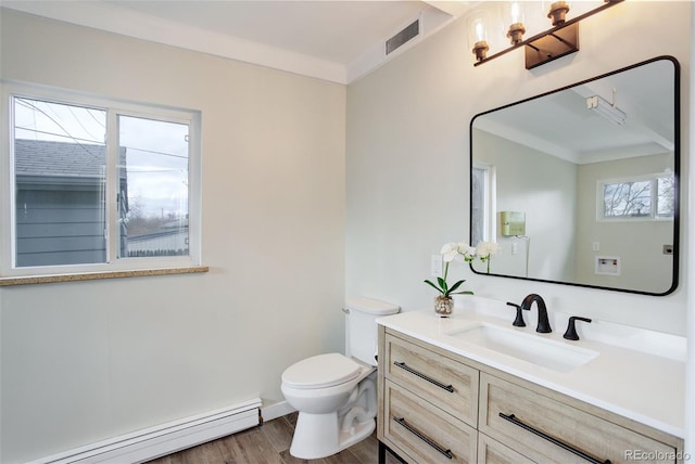 bathroom featuring toilet, a baseboard heating unit, wood finished floors, vanity, and crown molding