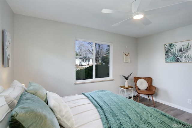 bedroom featuring a ceiling fan, baseboards, and wood finished floors