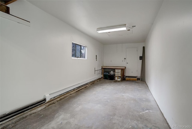 garage featuring a baseboard heating unit and a workshop area