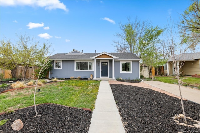 view of front of property with a shingled roof, a front lawn, and fence