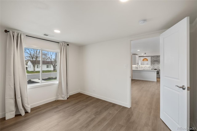 unfurnished room featuring recessed lighting, baseboards, visible vents, and light wood-style flooring